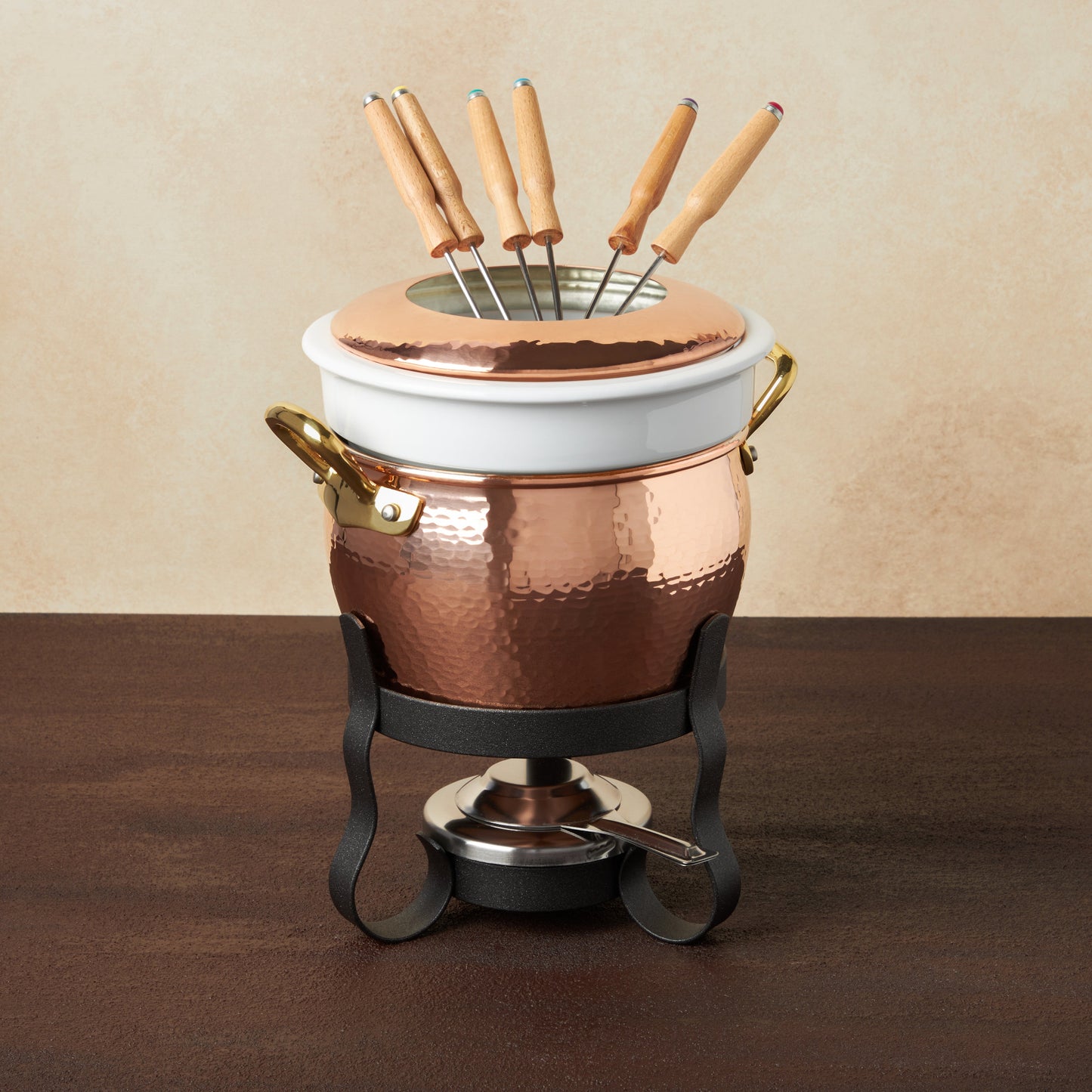 Hammered copper 11 Piece Fondue Michelle Set lined with high purity tin applied by hand over fire and bronze handles, from Ruffoni Historia collection. The full set includes: tin-lined copper fondue pot, porcelain insert, decorative wrought iron stand, gel fuel holder, and six fondue forks.