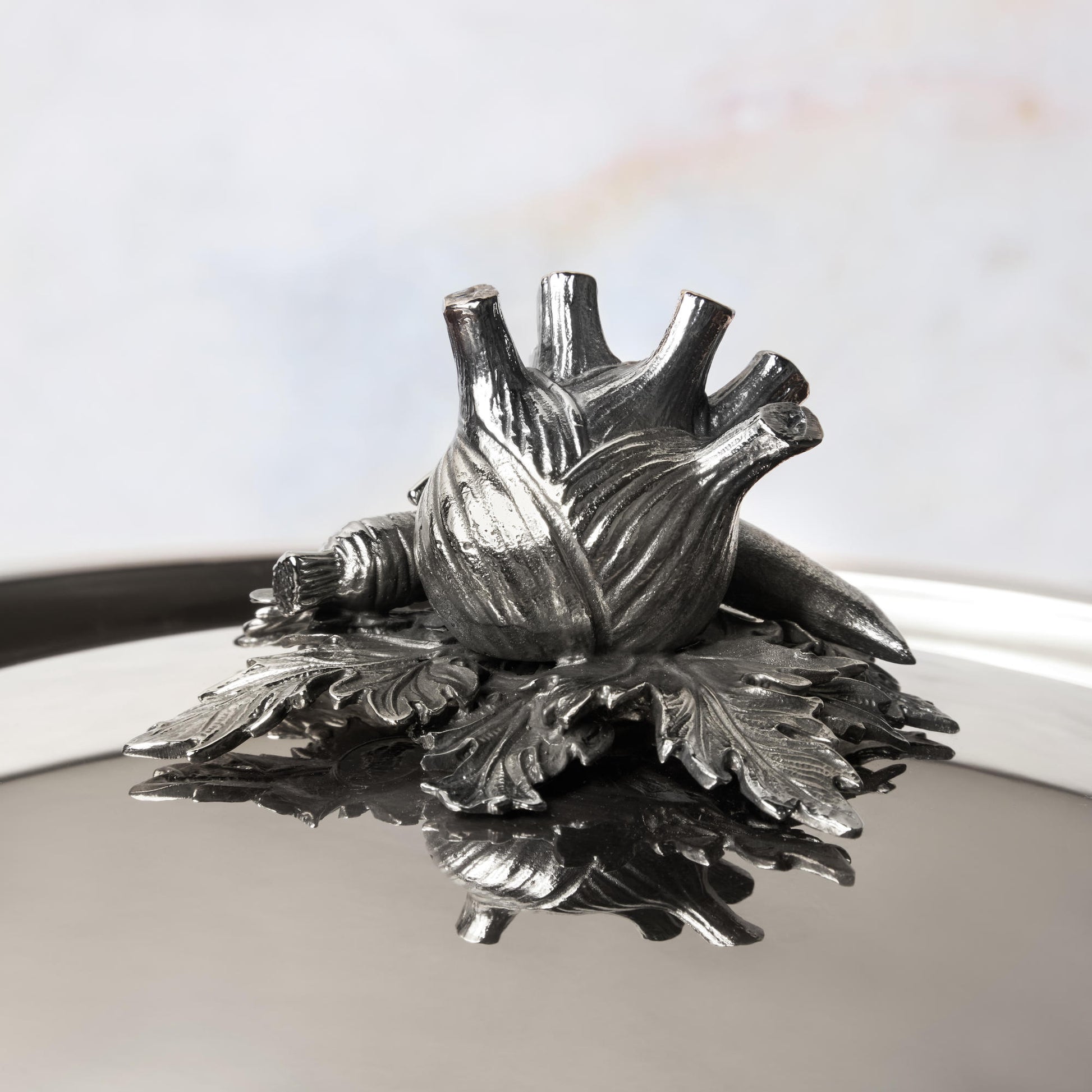 Decorated knob finial representing fennel, carrot and bean, cast in solid bronze and silver plated, on Opus Prima stainless steel lid by Ruffoni