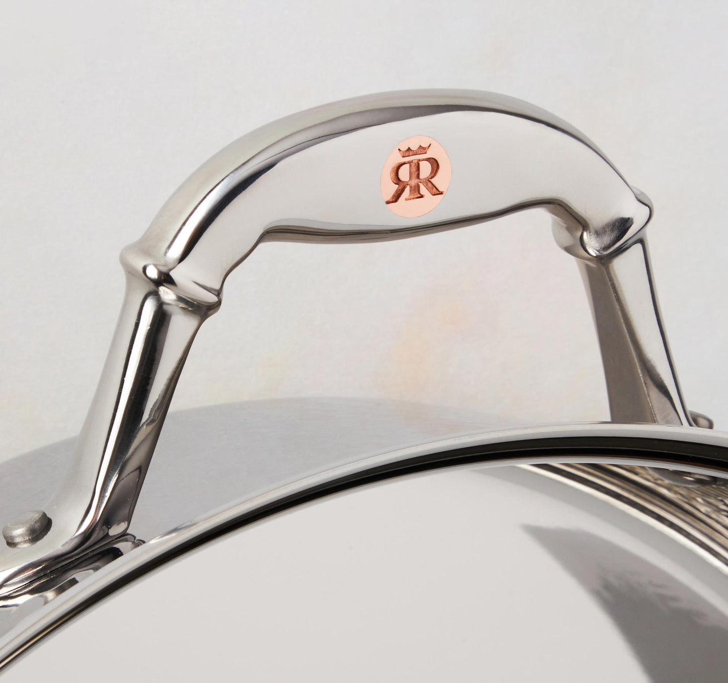 Comfortable stainless steel handle with decorative inlaid copper coin by Ruffoni