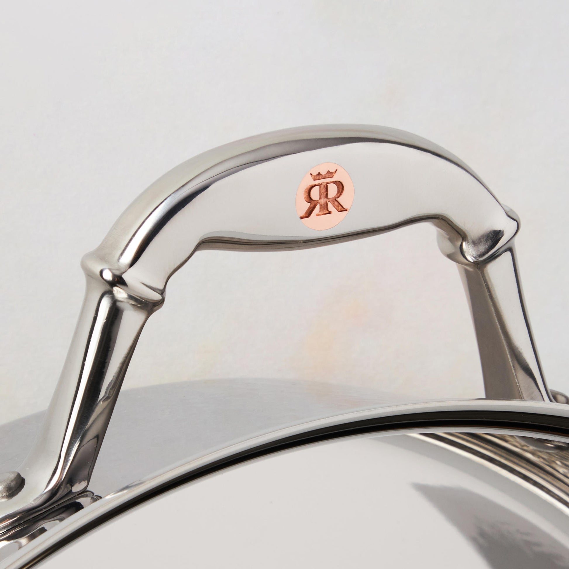 Comfortable stainless steel handle with decorative inlaid copper coin by Ruffoni