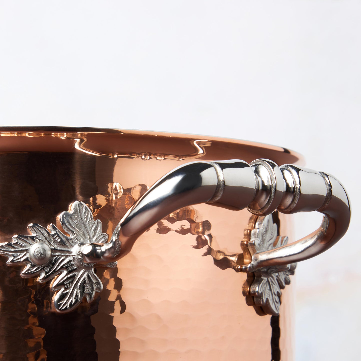 Beautiful stainless steel handle decorated with delicate leaves on Opus Cupra cookware by Ruffoni