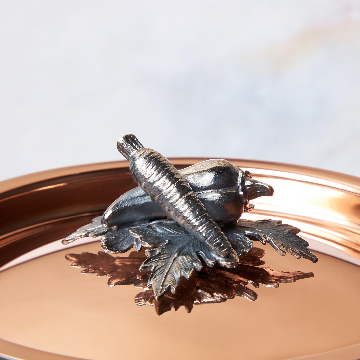 Decorated knob finial representing carrot and pepper, cast in solid bronze and silver plated, on Opus Cupra clad copper lid by Ruffoni