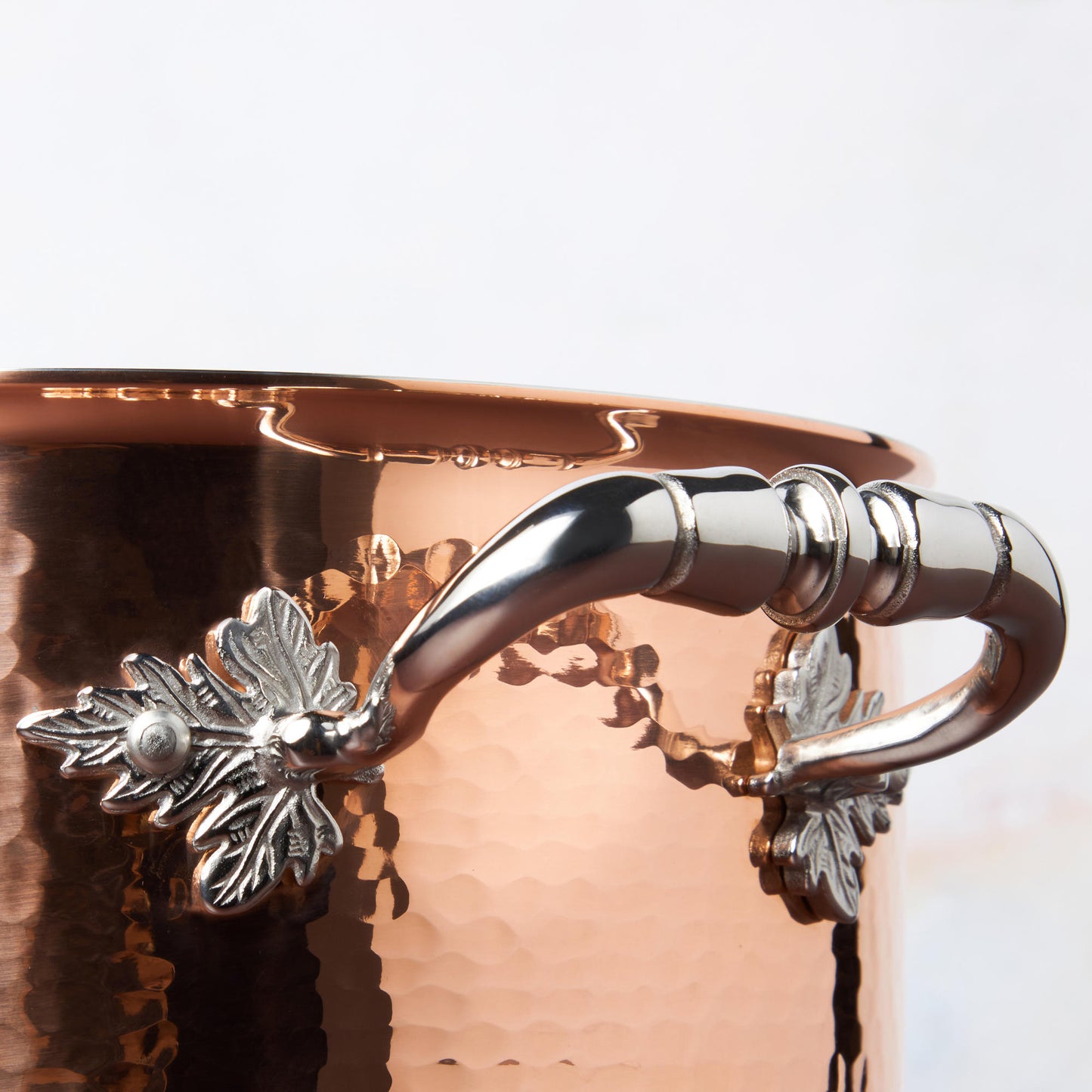 Beautiful stainless steel handle decorated with delicate leaves on Opus Cupra cookware by Ruffoni