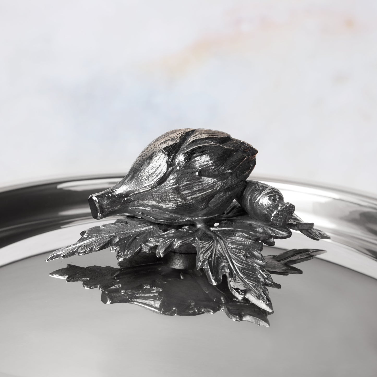 Decorated knob finial representing  artichoke  and carrot, cast in solid bronze and silver plated, on Opus Prima stainless steel lid by Ruffoni