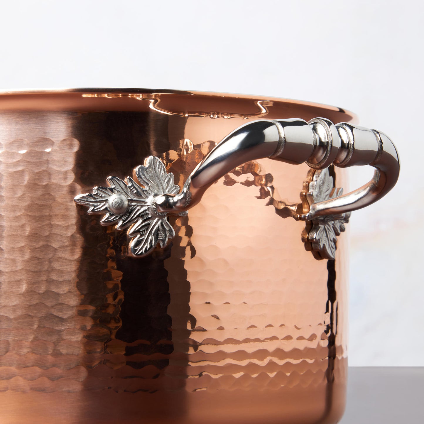 Beautiful stainless steel handle decorated with delicate leaves on cookware by Ruffoni