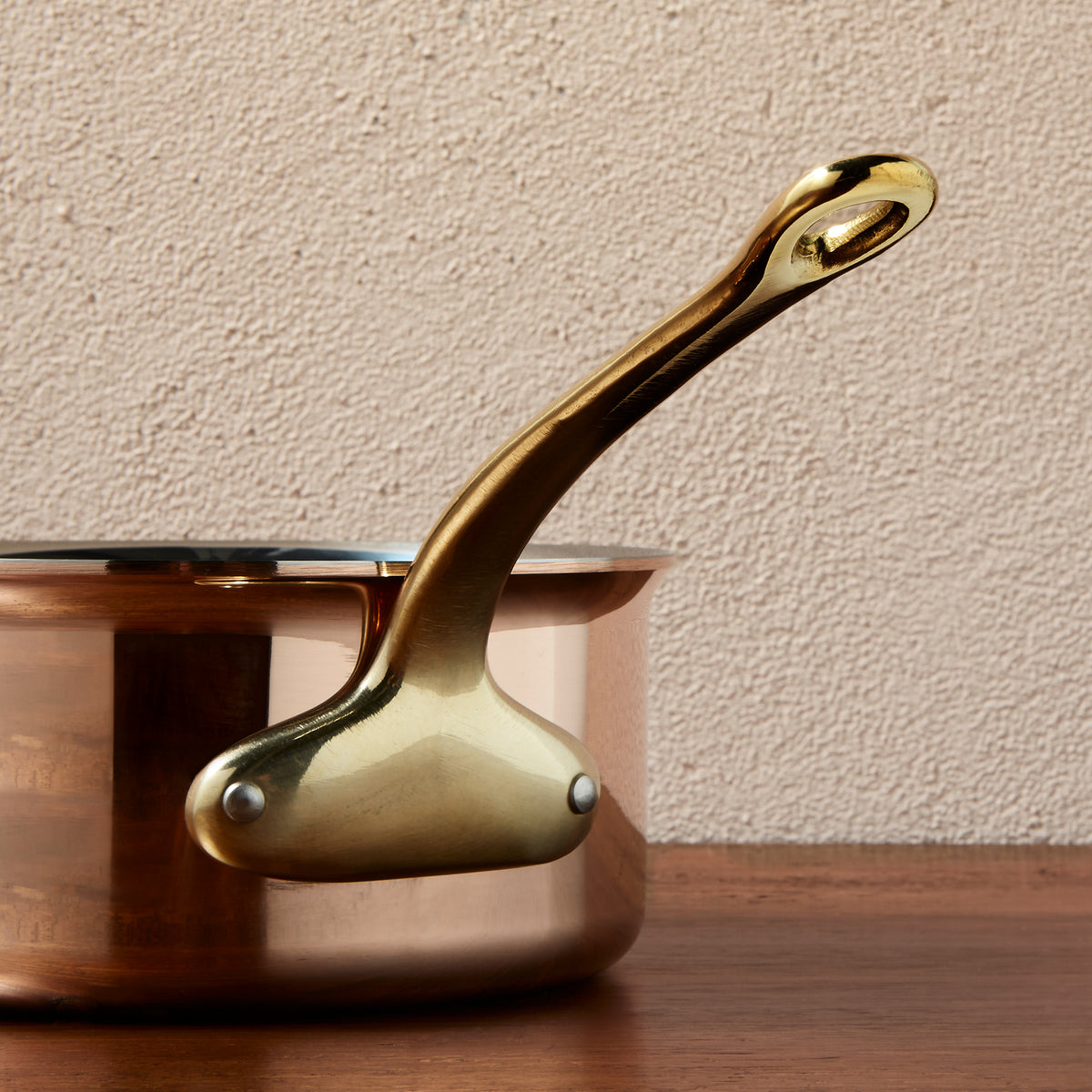 Side view of the  brass handle on a Ruffoni Olivia Cupra copper saucepan