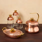 lotus 5 piece set including a copper tea kettle, copper 10" roaster and a set of 3 kitchen glass jars in glass and copper, all topped by lotus-shaped bronze knobs