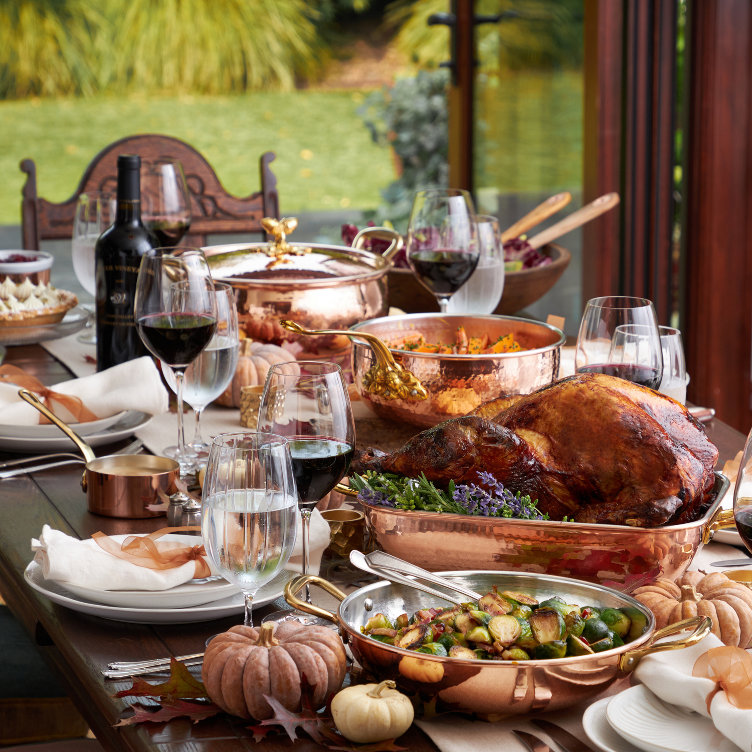 Fall gathering table set with Ruffoni copper cookware, roast turkey, wine and seasonal dishes.