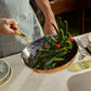 A chef ossing vegetables using Olivia Cupra frying pan