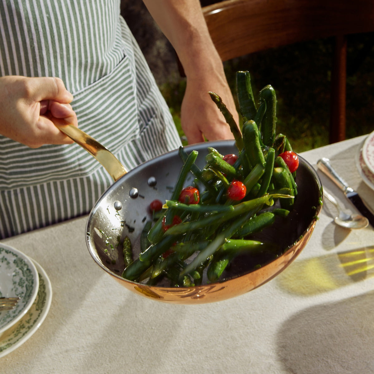 A chef ossing vegetables using Olivia Cupra frying pan