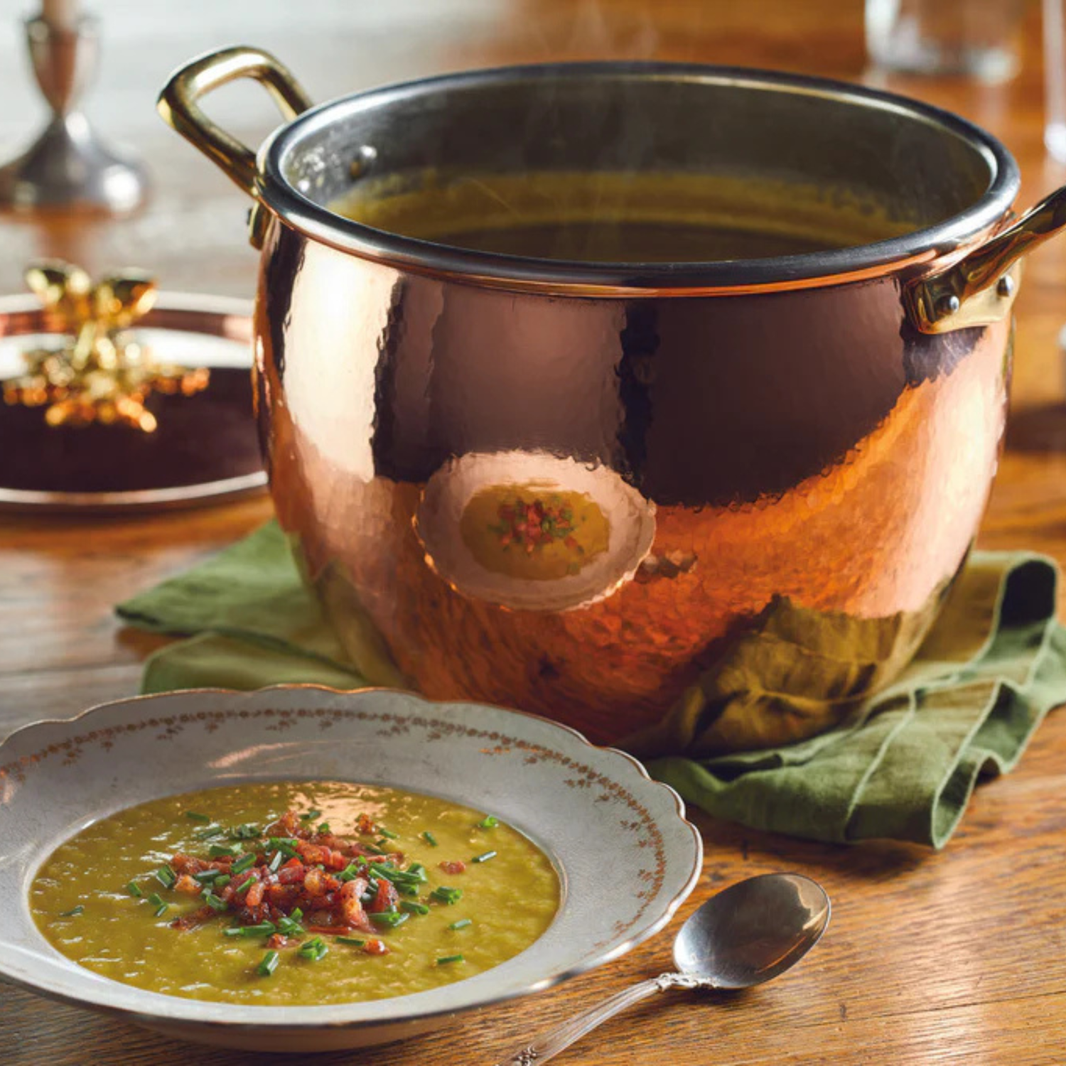 Copper pot with soup on a wooden table