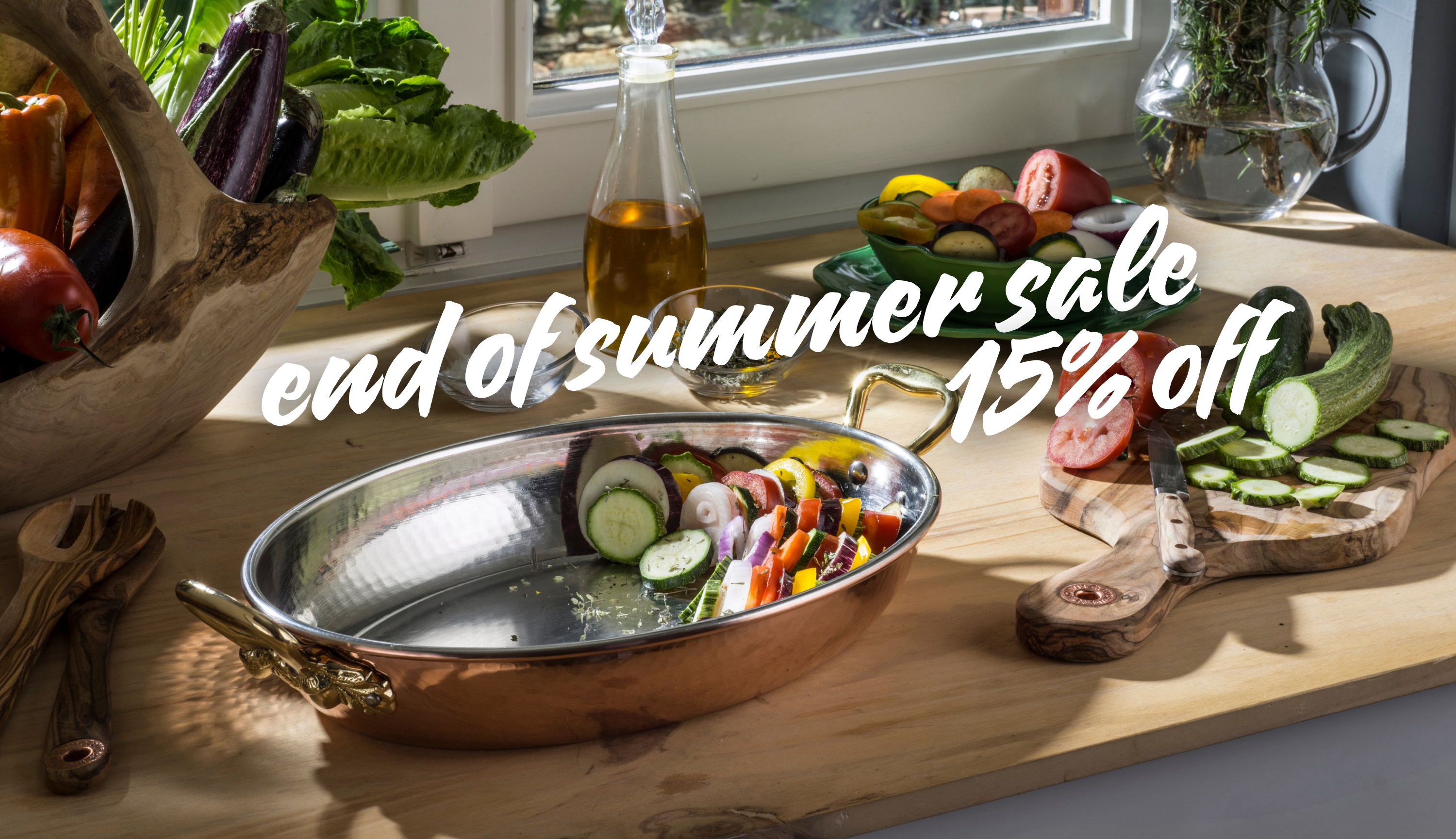 A copper roasting pan with gold-toned handles sits on a wooden cutting board in a kitchen setting, surrounded by fresh vegetables and a bottle of oil. A large white text overlay reads 'end of summer sale 15% off'.