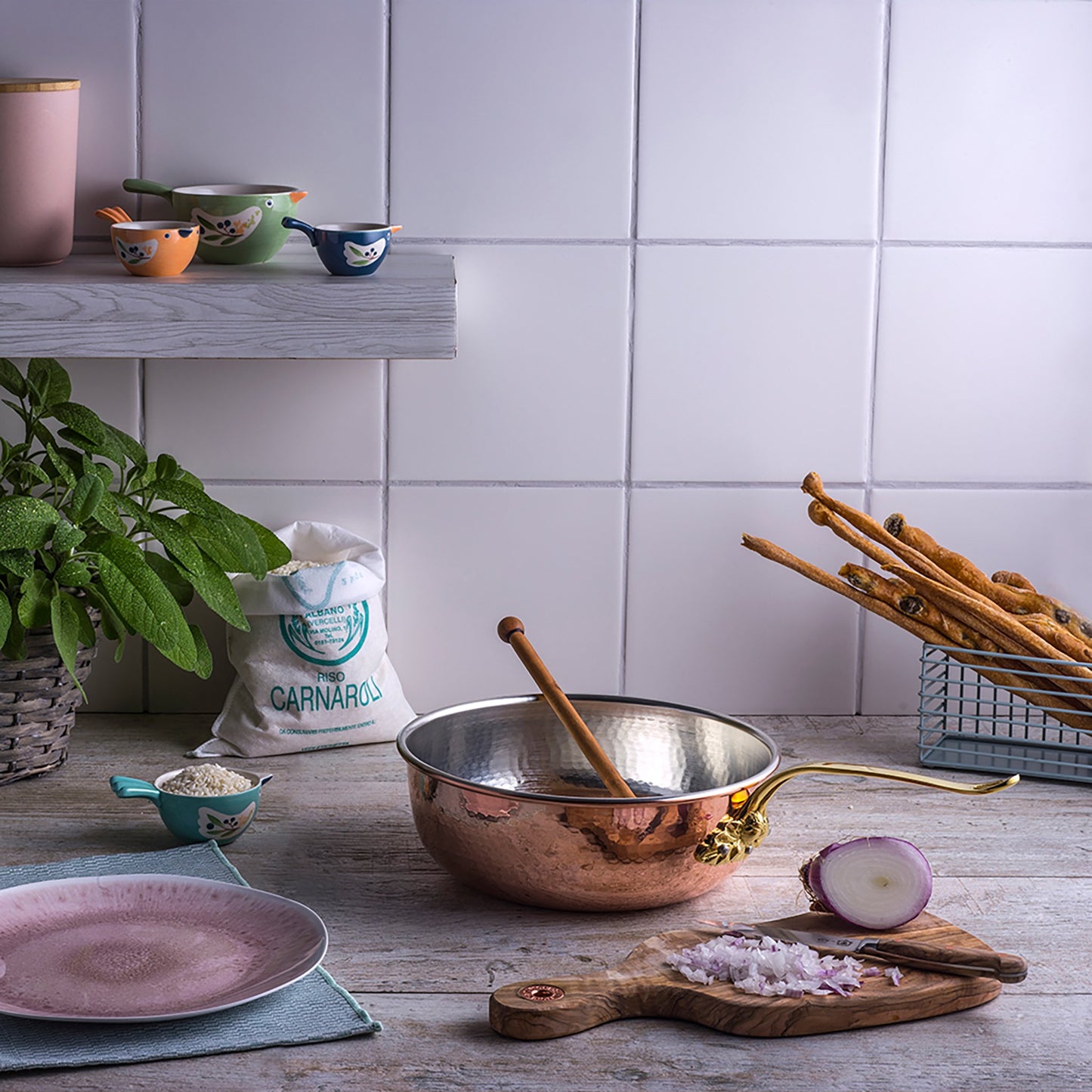 Stainless steel lined, copper chef pan in kitchen with diced onion and rice