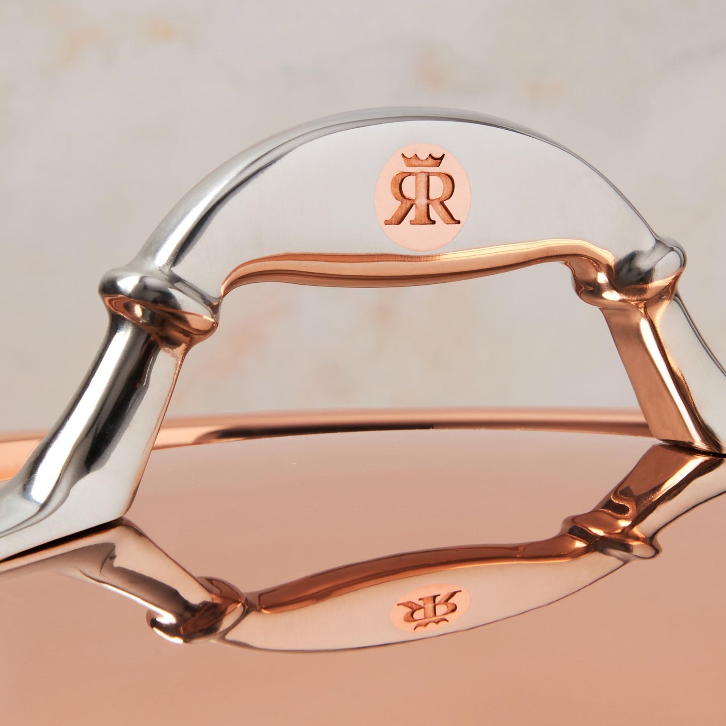 Comfortable lid handle in stainless steel with decorative inlaid copper coin by Ruffoni