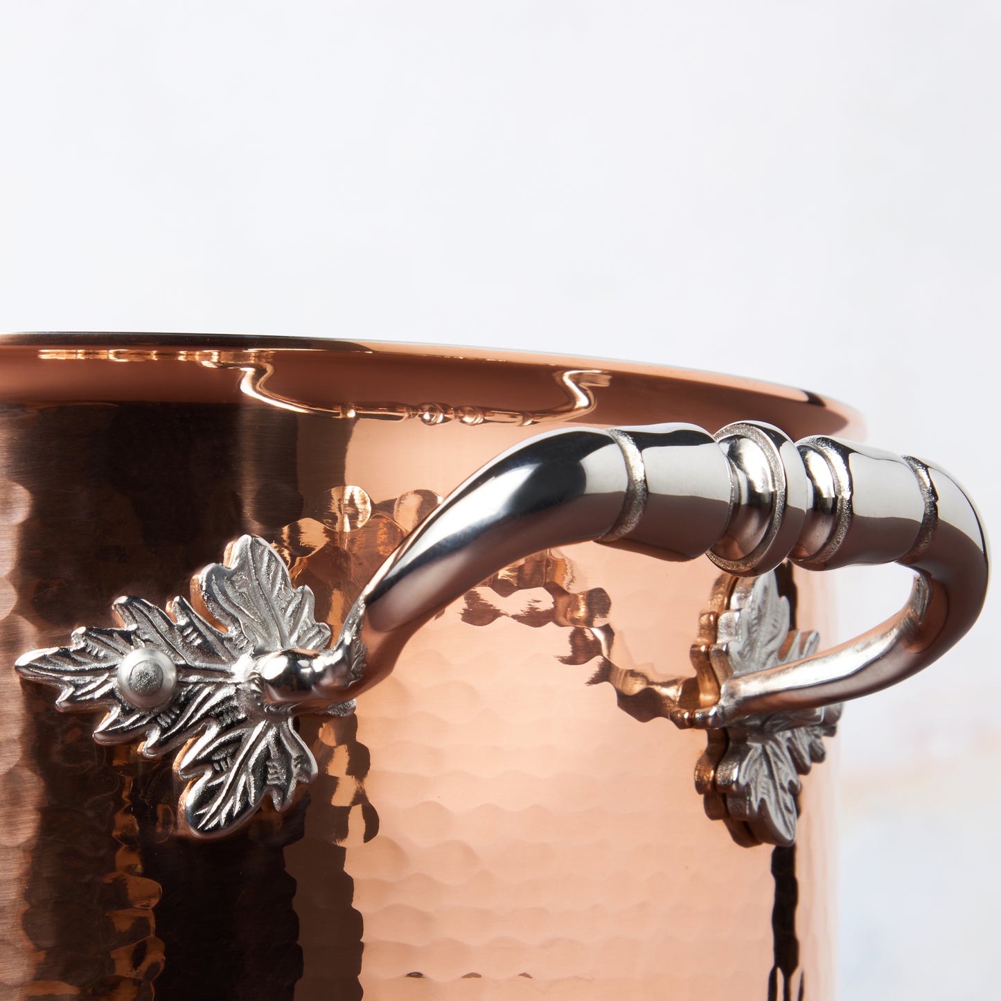 Beautiful stainless steel handle decorated with delicate leaves on Opus Cupra cookware by Ruffoni