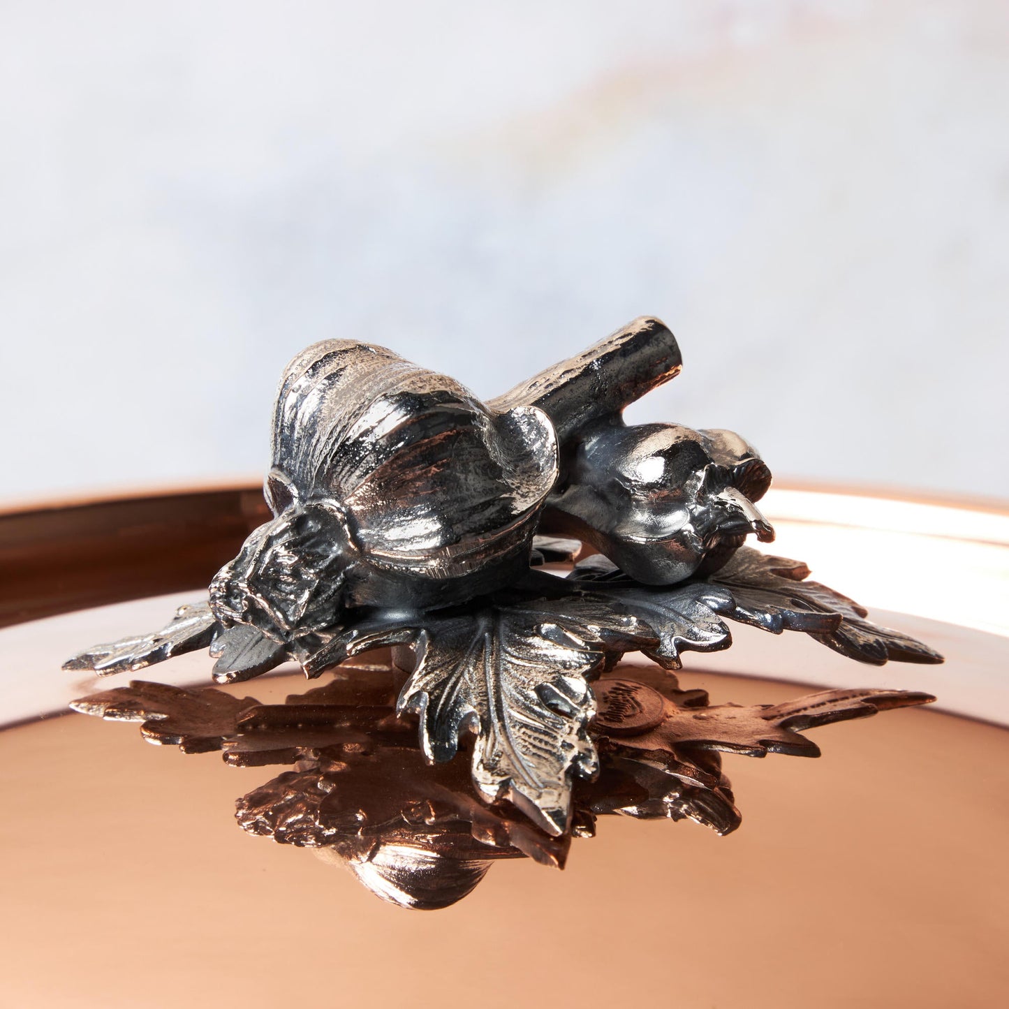 Decorated knob finial representing garlic and pepper, cast in solid bronze and silver plated, on Opus Cupra clad copper lid by Ruffoni