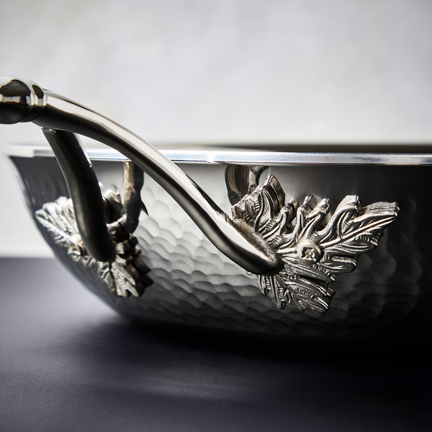 Beautiful clad stainless steel handle decorated with delicate leaves on Opus Prima cookware by Ruffoni