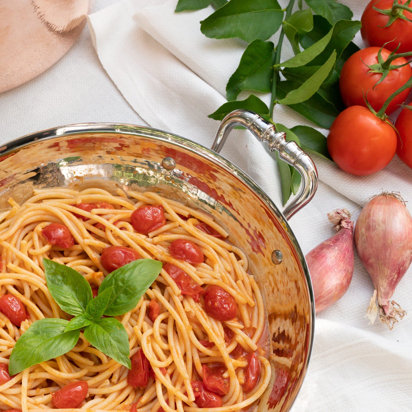 Nadia Caterina Munno, aka The Pasta Queen, presenting spaghetti with cherry tomatoes and basil, made in her Stella, the serving frying pan part of The Pasta Queen by Ruffoni Collection of hammered copper and stainless steel cookware