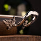 Closeup of the Ruffoni logo on the stainless steel rivet securing the leaf-decorated handle on Stella, part of The Pasta Queen by Ruffoni Collection of Made in Italy cookware